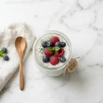 Chia seed pudding with water in a glass jar topped with fresh berries