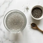 Glass of soaked chia seed water next to a bowl of dry chia seeds
