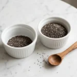 how many chia seeds per day: two tablespoons of chia seeds in a bowl on white marble